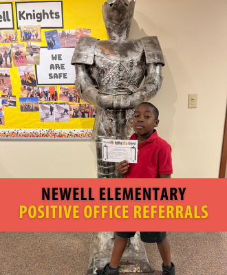 African American Newell student standing proudly with the Newell Knight mascot holding certificate.